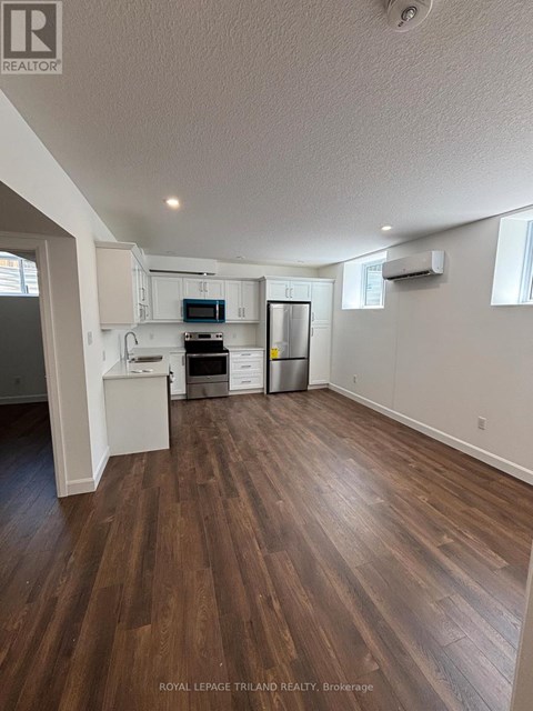 A kitchen with white cabinets and a wooden floor.