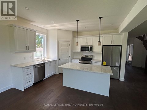 A kitchen with white cabinets and a granite countertop.
