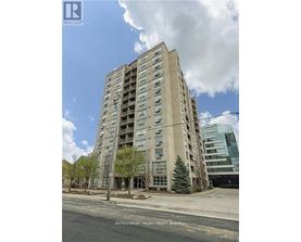 A tall residential building with a balcony on the second floor from the front.
