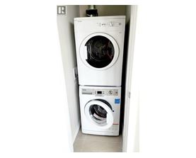 A white washing machine is placed in a small space.