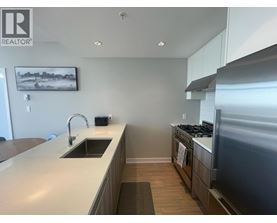 A modern kitchen with a sink, stove, and oven.