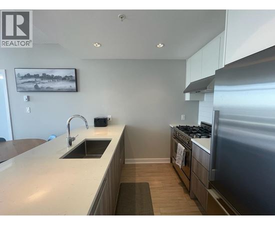 A modern kitchen with a sink, stove, and oven.