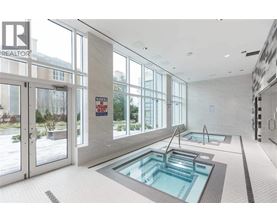 A swimming pool inside a building with a glass door.