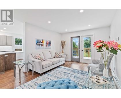 A living room with a couch, a coffee table, and a painting on the wall.
