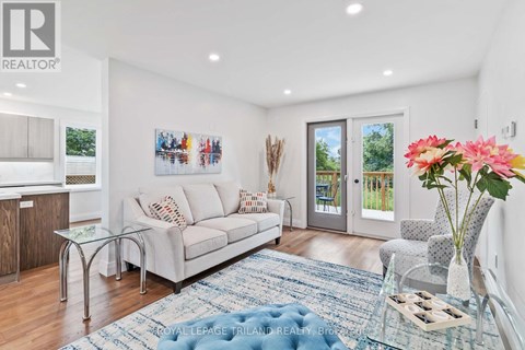 A living room with a couch, a coffee table, and a painting on the wall.