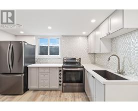 A modern kitchen with a refrigerator, oven, and sink.