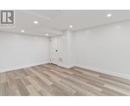 A room with wooden flooring and white walls.