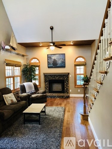 A living room with a fireplace and a painting on the wall.