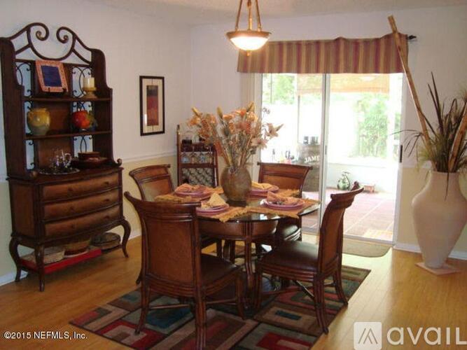 A dining room with a wooden table and chairs.