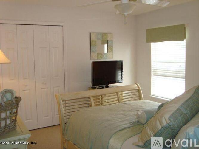 A bedroom with a bed, chair, and television.