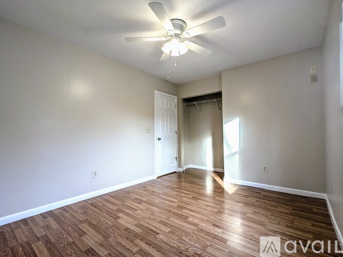 A room with a ceiling fan and wooden flooring is available for rent.