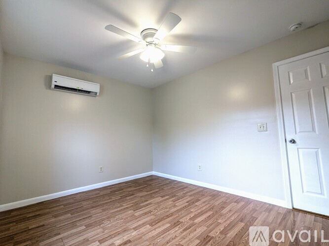 A room with a ceiling fan and a door.