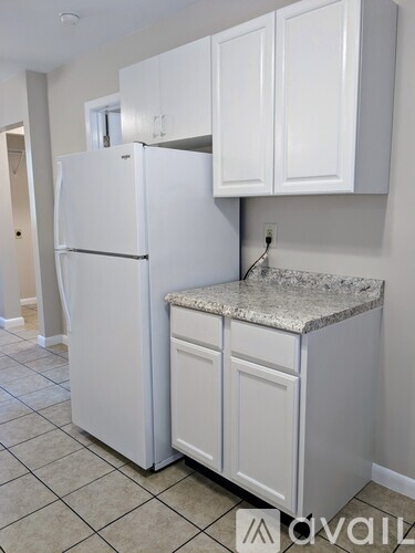 A white refrigerator and cabinets in a kitchen.