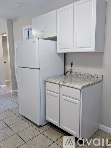 A white refrigerator and cabinets in a kitchen.