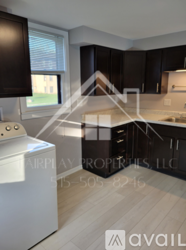 A modern kitchen with a washing machine and a window.