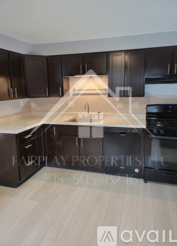 A modern kitchen with dark wood cabinets and a white countertop.