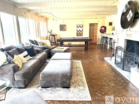 A living room with a grey couch and a fireplace.