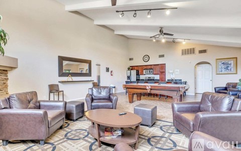 A living room with a brown leather couch and a wooden coffee table.