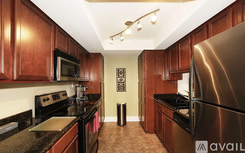 A kitchen with dark wood cabinets and a black stove top oven.