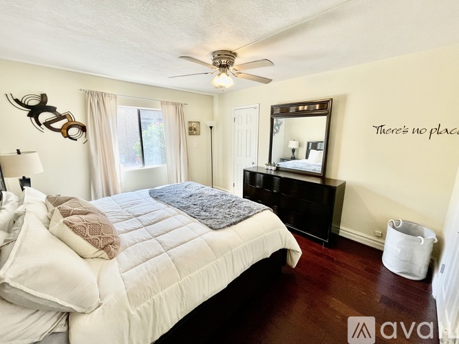A bedroom with a large bed and a mirror on the wall.