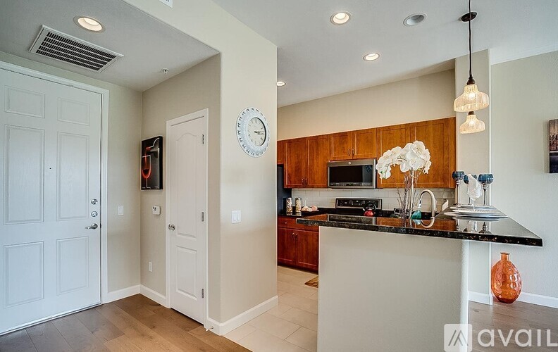 A kitchen with a black counter top and wooden cabinets.