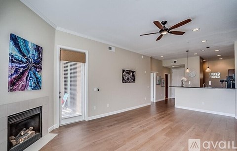 A spacious living room with a fireplace and a painting on the wall.