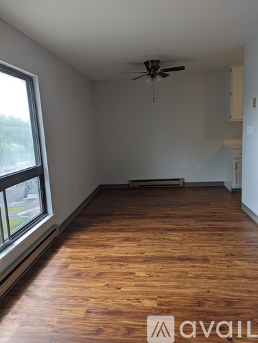 A room with wooden floors and a ceiling fan.