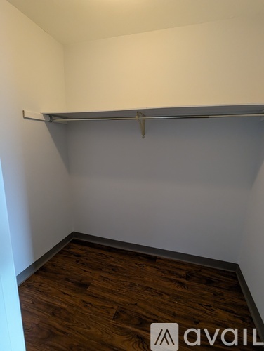 A room with a wooden floor and a white wall.
