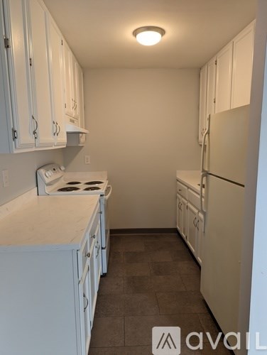 A kitchen with white cabinets and a white fridge.