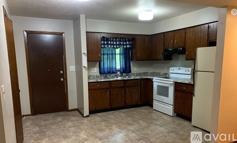 A kitchen with wooden cabinets and a white refrigerator.