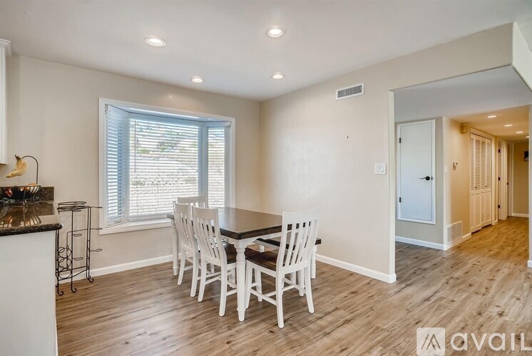 A dining room with a table and chairs.