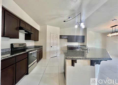 A kitchen with brown cabinets and a granite countertop.