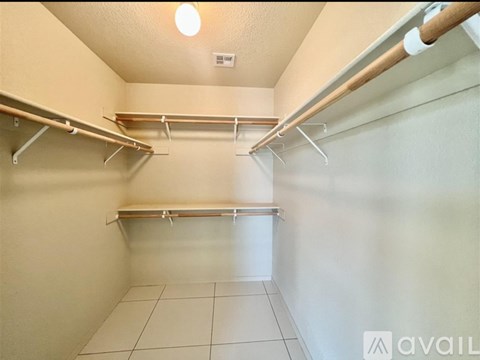 A small, empty room with a tiled floor and a row of shelves.