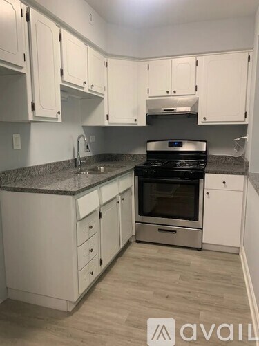 A kitchen with white cabinets and a black stove top oven.