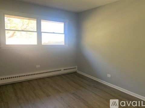 A room with a window and a radiator on the floor.