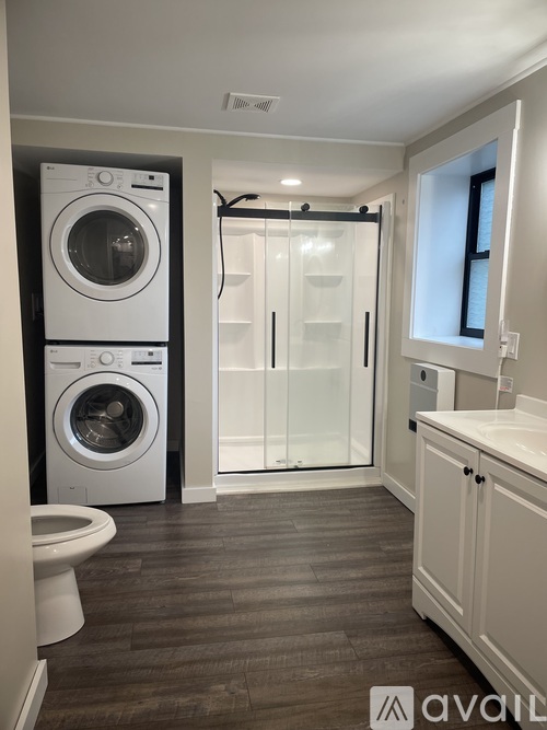 A modern laundry room with a washer and dryer stacked on top of each other.