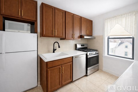 A kitchen with brown cabinets and white appliances.