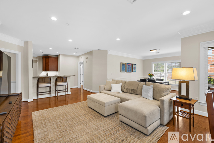 A living room with a beige sofa and a rug.