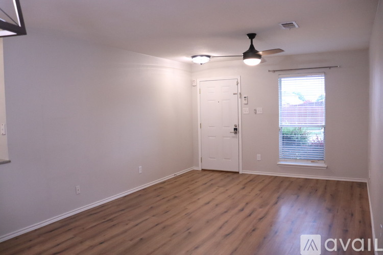 A room with wooden flooring and a ceiling fan.