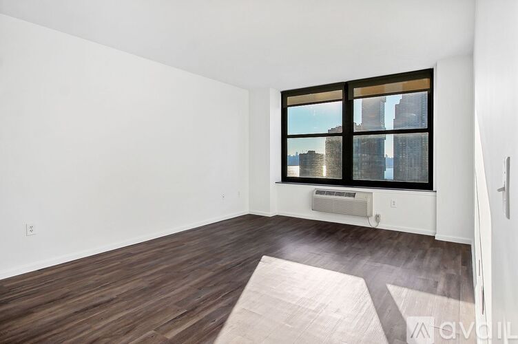 A room with a large window and a wooden floor.