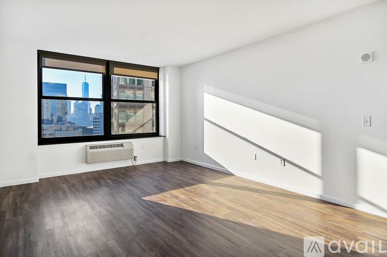 A room with a large window and a wooden floor.