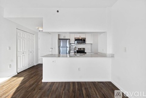 A kitchen with white cabinets and a wooden floor.
