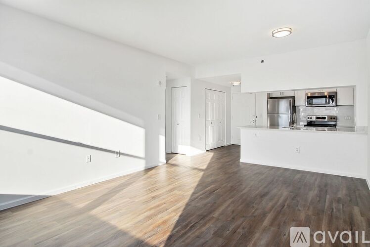 A spacious room with wooden floors and white walls.