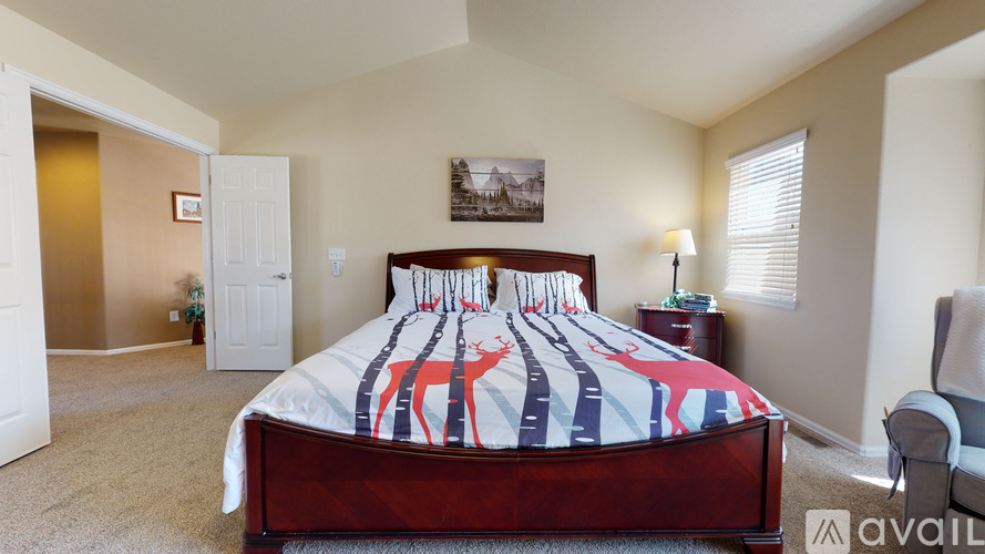 A bedroom with a bed, a chair, and a painting on the wall.