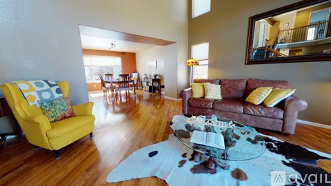 A living room with a yellow chair and a brown couch.