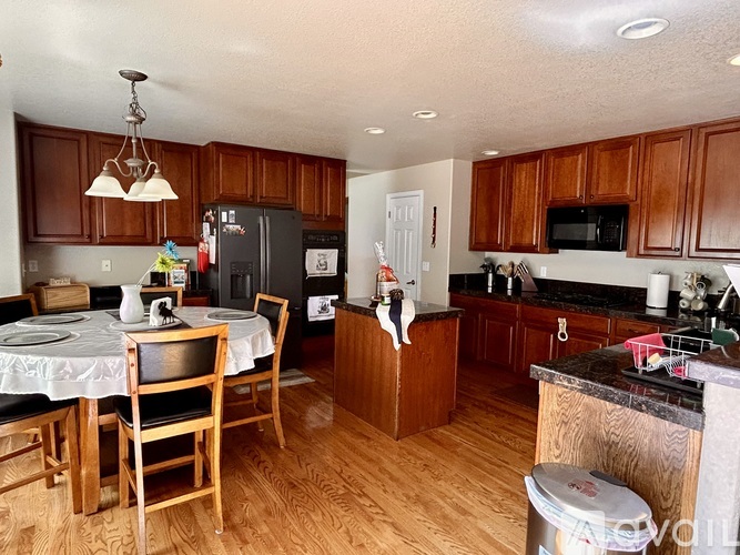 A kitchen with wooden cabinets and a black refrigerator.