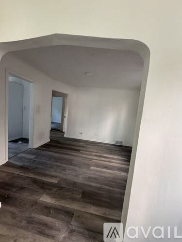 A room with a white door, a window, and a broom on the floor.