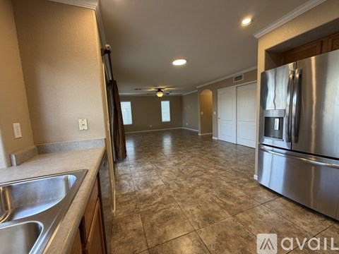 A kitchen with a stainless steel refrigerator and a sink.