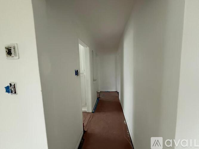 A long white hallway with a brown carpet.