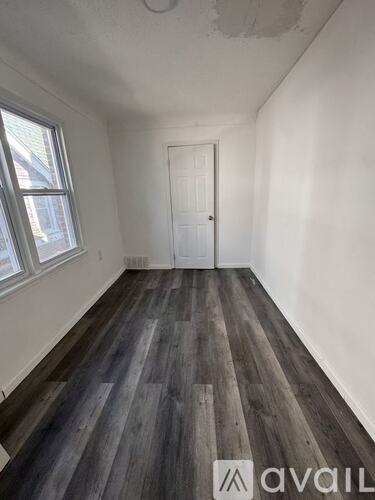 A room with a door, a window, and a ceiling fan.